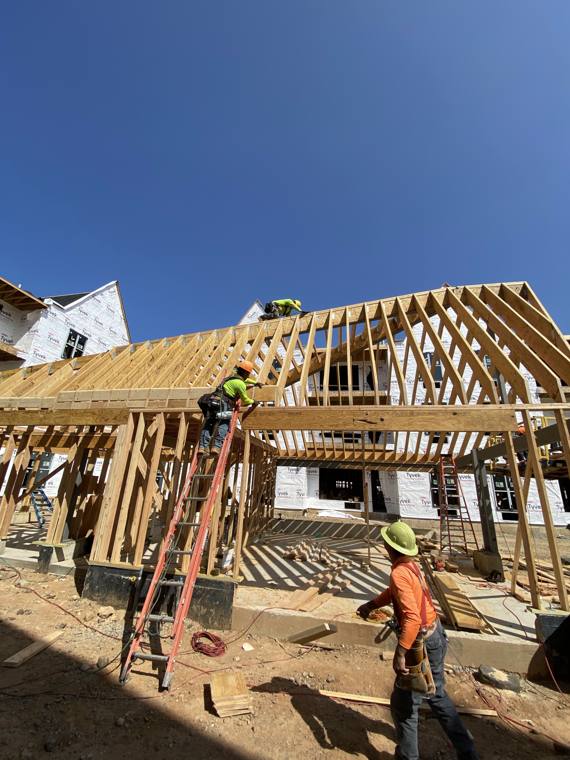 Crew setting gable roof trusses on a multi-family building